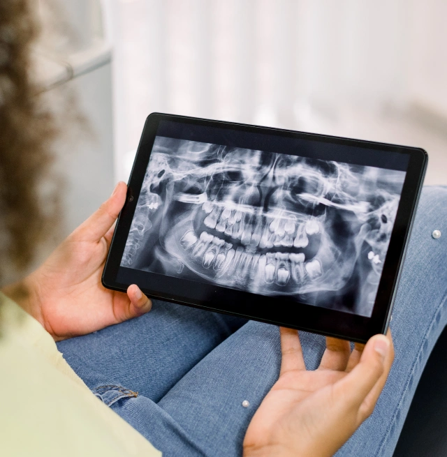 A person holding a tablet displaying digital X rays at Chatfield Smiles in Littleton, CO