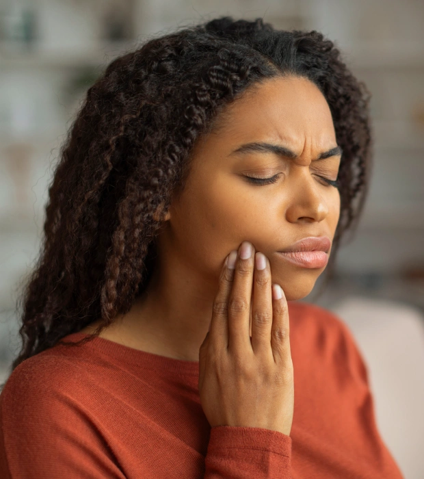 Woman holding her jaw in dental pain