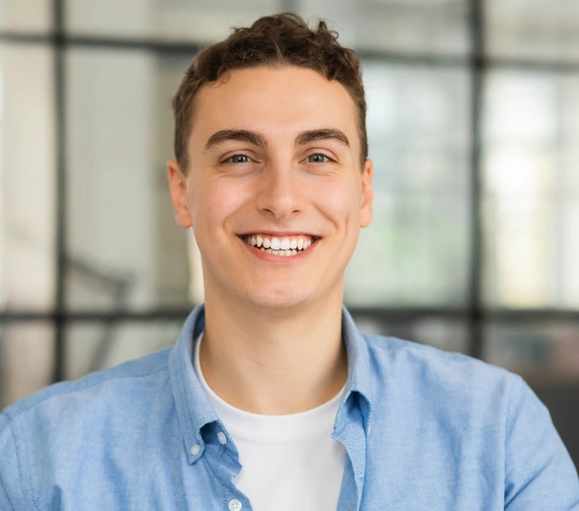 A young man smiling confidently, representing family general dentistry services at Chatfield Smiles