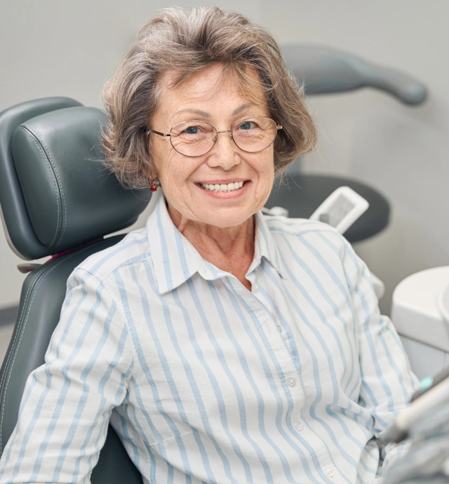A senior dental patient smiling after receiving successful periodontal gum disease treatment