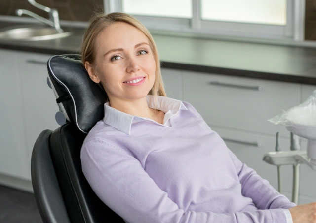 Happy new patient smiling in a comfortable dental chair at Chatfield Smiles in Littleton, CO