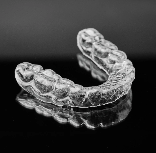 A clear custom night guard prosthetic used to prevent teeth grinding and bruxism