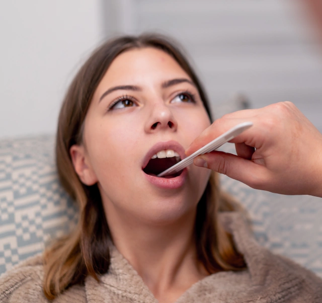 A dental professional performing a preventive oral cancer screening during an exam