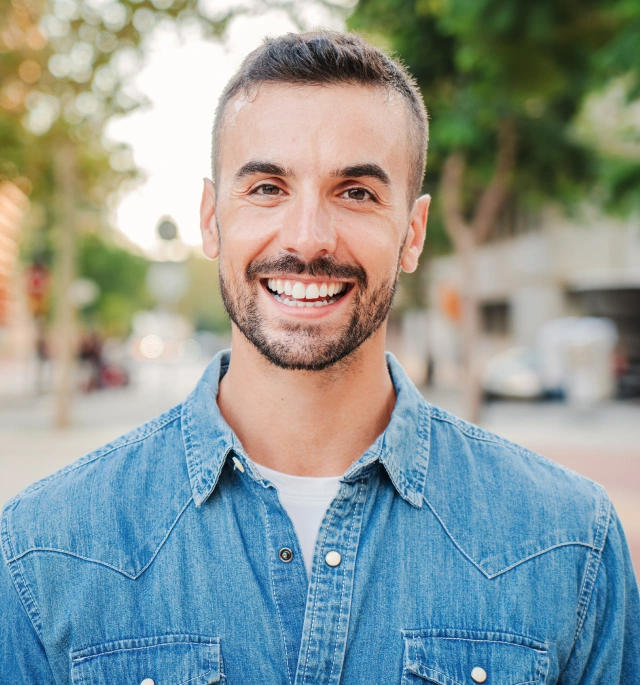 A happy male patient showing the results of restorative dentistry treatments at Chatfield Smiles