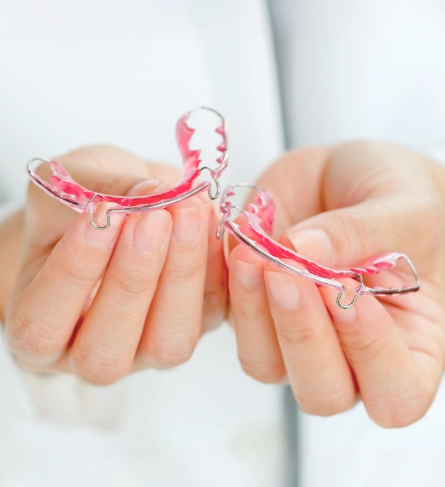 A person holding a custom orthodontic clear aligner or teeth retainer